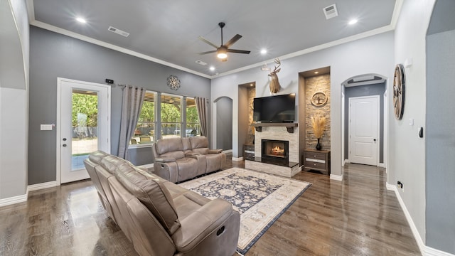 living room with ornamental molding, a fireplace, dark hardwood / wood-style floors, and ceiling fan