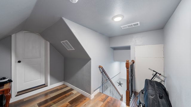 bonus room featuring dark wood-type flooring and vaulted ceiling