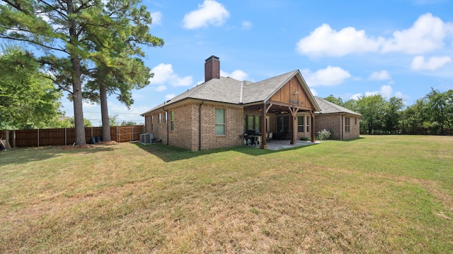 rear view of property featuring a patio, cooling unit, and a lawn