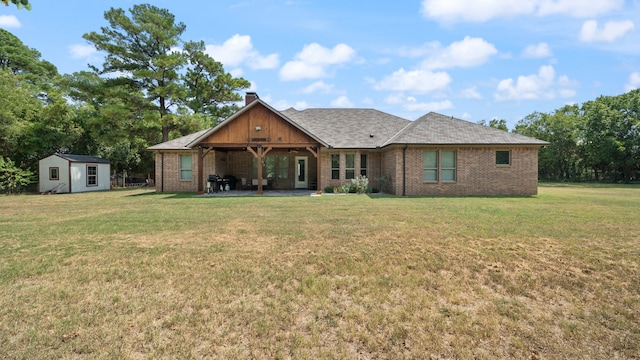 view of front of house featuring a patio area, a front yard, and a storage shed