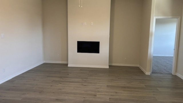 unfurnished living room featuring dark wood-type flooring