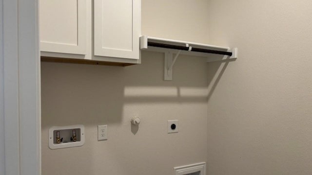 clothes washing area with hookup for a washing machine, cabinets, and electric dryer hookup