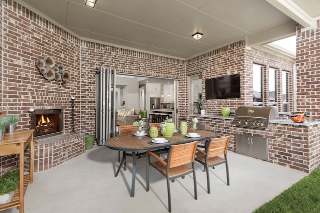 view of patio / terrace featuring area for grilling, an outdoor brick fireplace, and grilling area