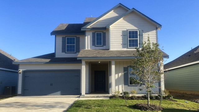 view of front of home with central air condition unit, a front lawn, and a garage