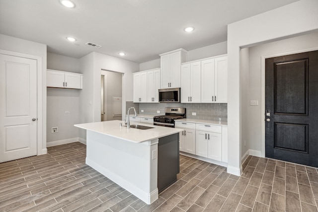 kitchen with light hardwood / wood-style floors, a center island with sink, stainless steel appliances, and sink