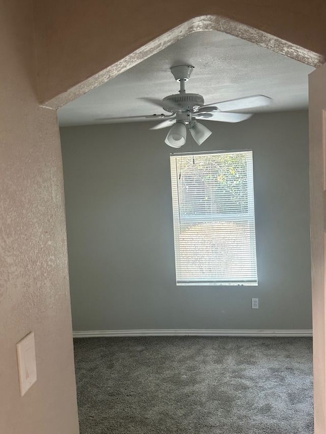 carpeted empty room featuring a textured ceiling and ceiling fan