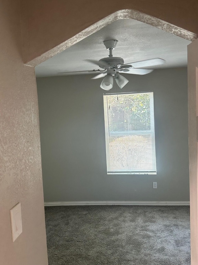 unfurnished room with baseboards, ceiling fan, carpet flooring, and a textured ceiling
