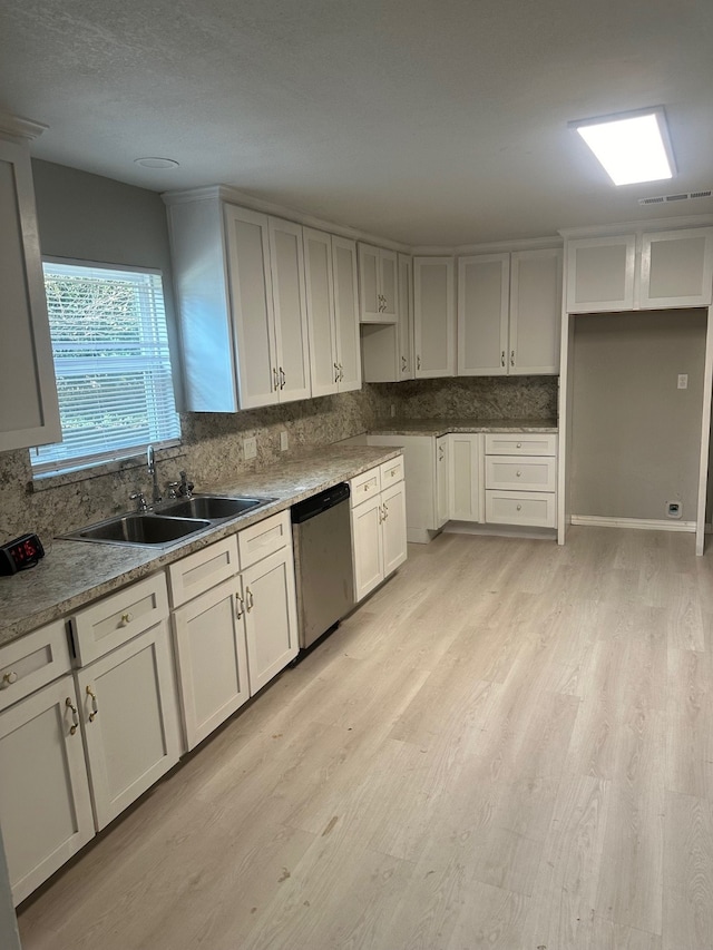 kitchen with light hardwood / wood-style flooring, sink, light stone countertops, stainless steel dishwasher, and tasteful backsplash