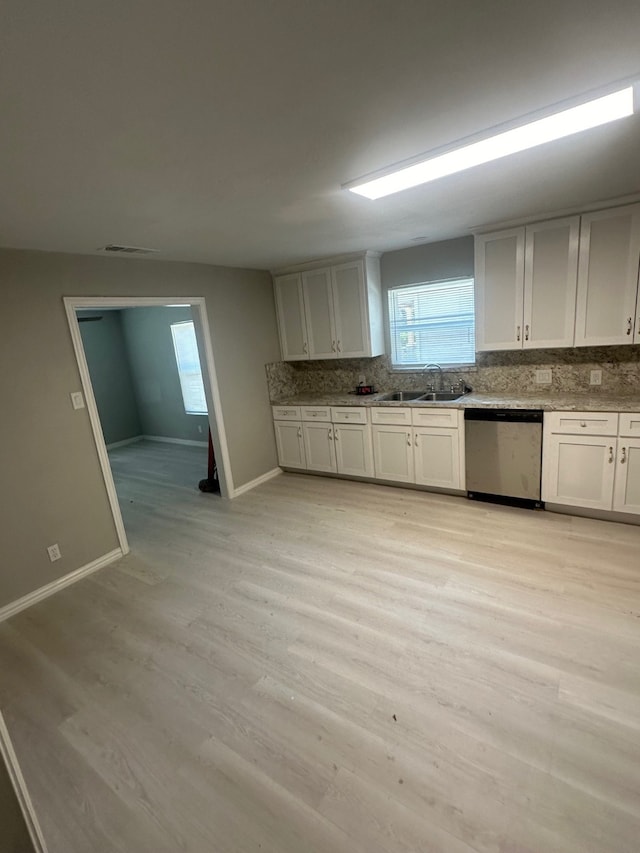 kitchen featuring light hardwood / wood-style floors, white cabinets, stainless steel dishwasher, and sink