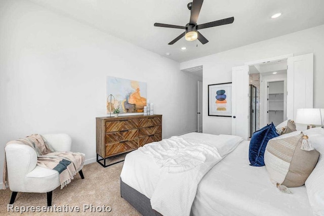 bedroom featuring a spacious closet, ceiling fan, a closet, and light colored carpet