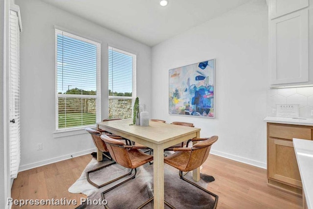 dining area with a wealth of natural light and light hardwood / wood-style flooring