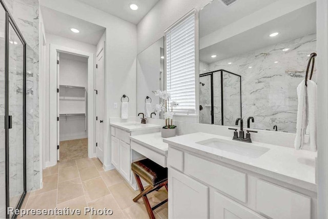 bathroom featuring a shower with door, vanity, and tile patterned floors