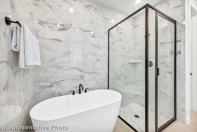 bathroom featuring tile walls, separate shower and tub, and tile patterned flooring