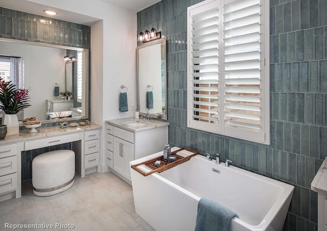 bathroom featuring tile walls, vanity, and a washtub