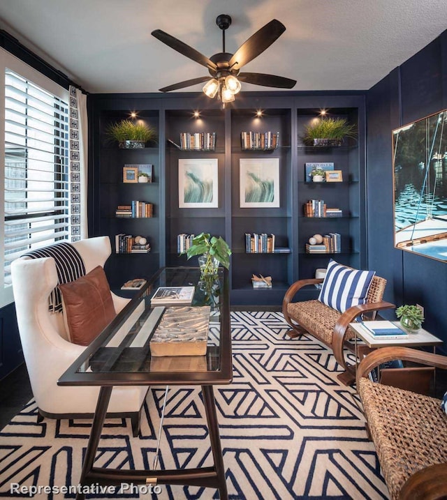 carpeted office space with ceiling fan, built in features, and a textured ceiling