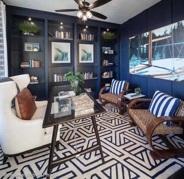 carpeted home office featuring ceiling fan and built in shelves