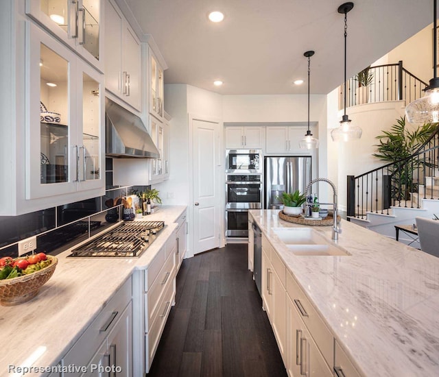 kitchen featuring white cabinetry, dark hardwood / wood-style floors, sink, pendant lighting, and stainless steel appliances