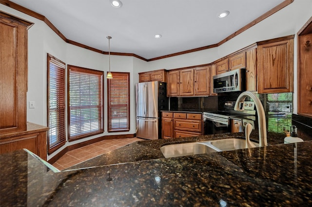 kitchen featuring hanging light fixtures, stainless steel appliances, backsplash, crown molding, and light tile patterned flooring