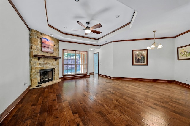 unfurnished living room featuring a stone fireplace, ornamental molding, a raised ceiling, and dark hardwood / wood-style flooring