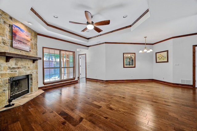 unfurnished living room with a stone fireplace, wood-type flooring, a tray ceiling, and ornamental molding