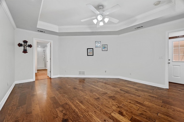 spare room featuring hardwood / wood-style floors, crown molding, ceiling fan, and a raised ceiling