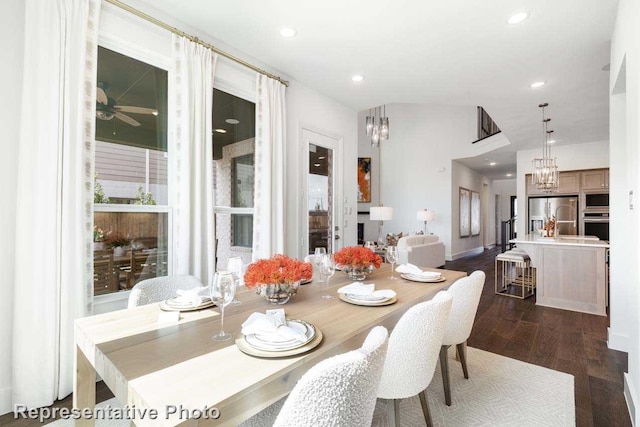 dining area featuring vaulted ceiling, dark hardwood / wood-style floors, and ceiling fan with notable chandelier