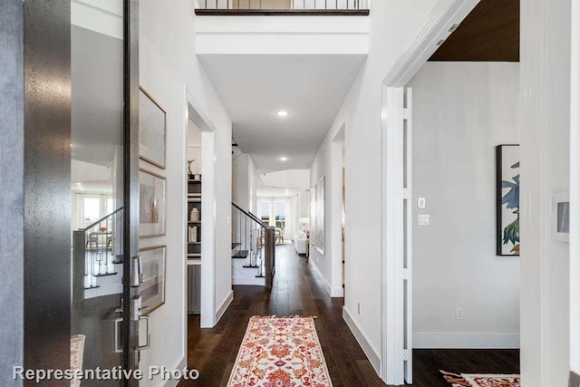 hallway with dark wood-type flooring and a wealth of natural light