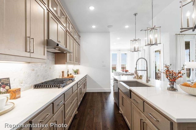 kitchen featuring a kitchen island with sink, dark wood-type flooring, sink, pendant lighting, and stainless steel appliances