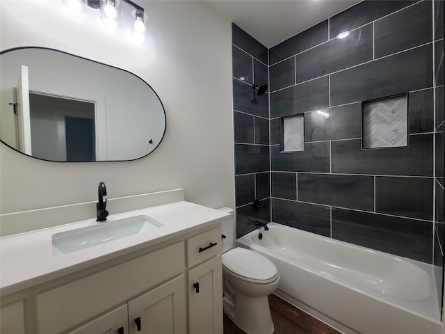 full bathroom featuring vanity, toilet, hardwood / wood-style floors, and tiled shower / bath