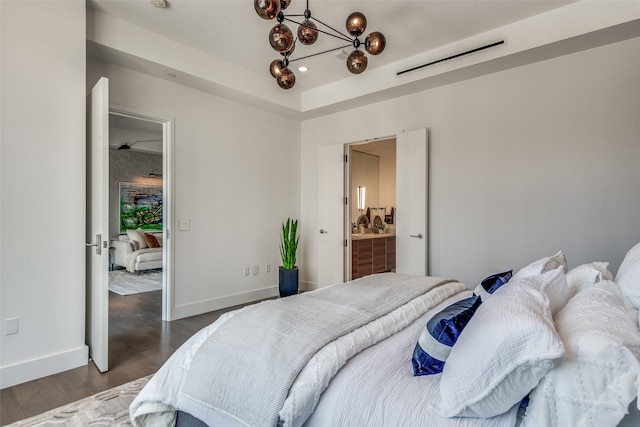 bedroom featuring connected bathroom and dark hardwood / wood-style flooring