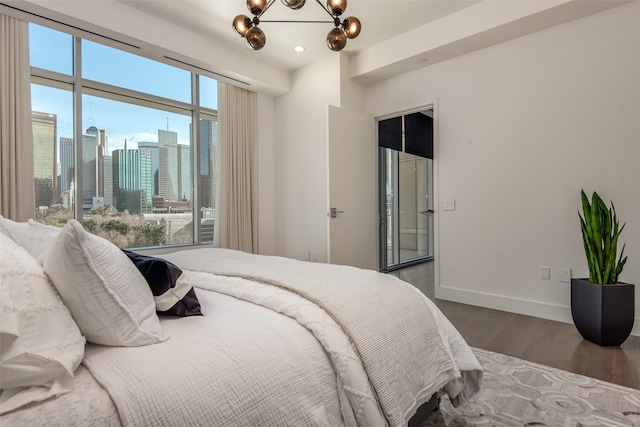 bedroom with hardwood / wood-style flooring and an inviting chandelier