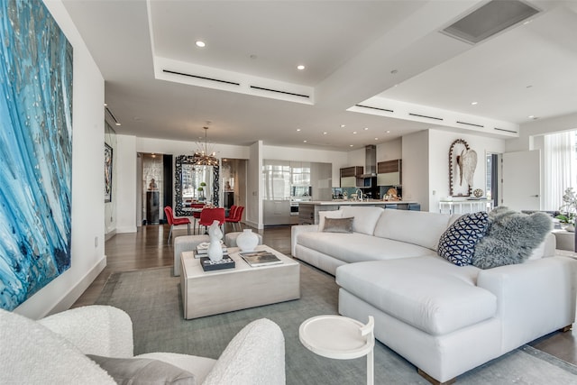 living room with hardwood / wood-style flooring, sink, a chandelier, and a wealth of natural light