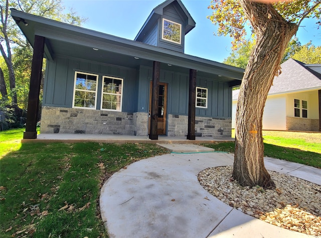 view of front of house with a front yard and a porch