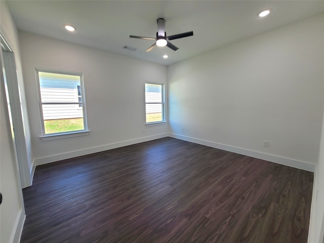 spare room featuring dark wood-type flooring and ceiling fan