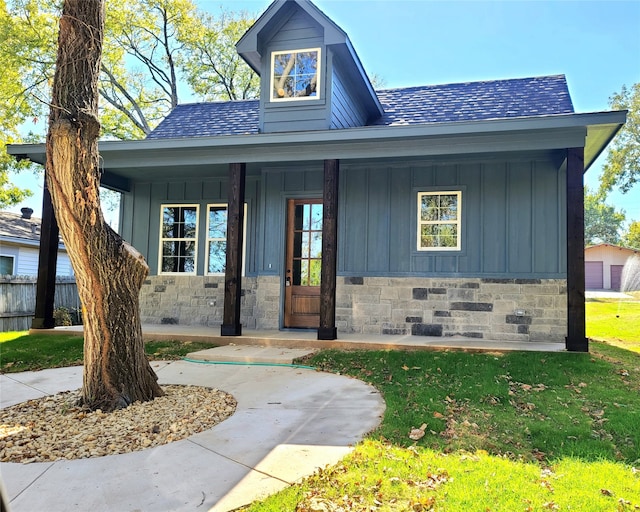 view of front of house featuring a porch, a front yard, and a garage