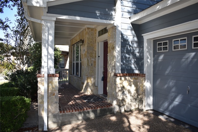 property entrance with a garage and a porch