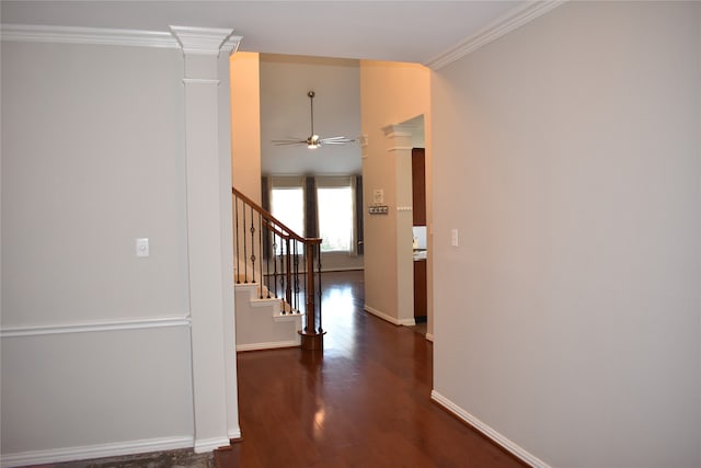 hallway with dark wood-type flooring, decorative columns, and ornamental molding