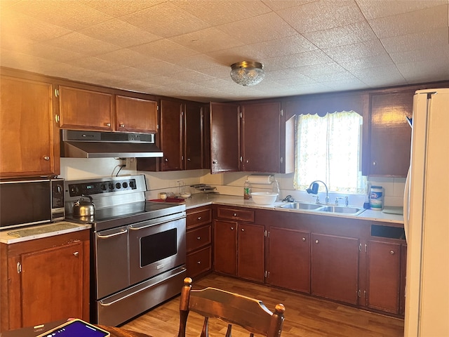 kitchen featuring white fridge, light hardwood / wood-style flooring, sink, and stainless steel electric range oven