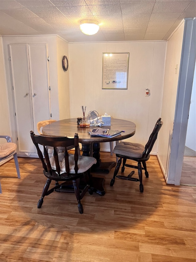 dining room with a textured ceiling and light wood-type flooring