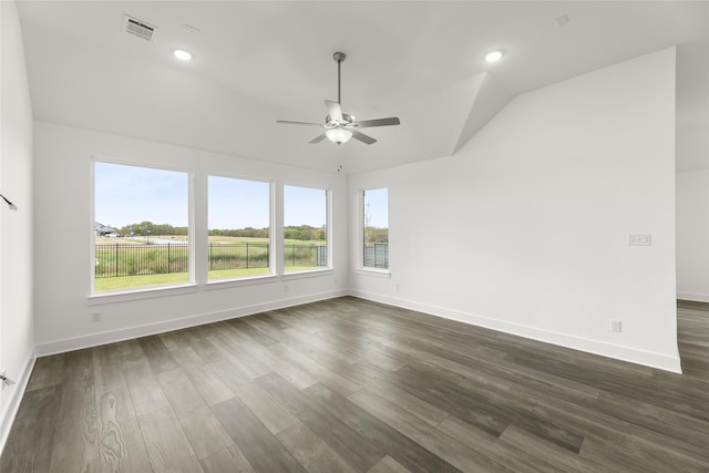 empty room with lofted ceiling, ceiling fan, and dark hardwood / wood-style flooring