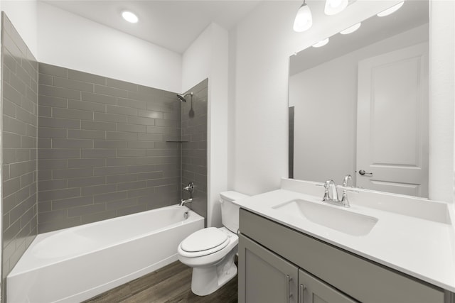 full bathroom featuring vanity, toilet, hardwood / wood-style flooring, and tiled shower / bath