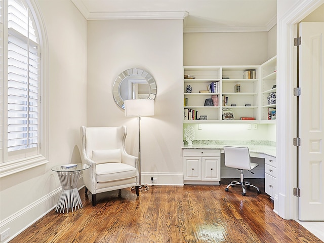 office featuring ornamental molding, a healthy amount of sunlight, built in desk, and dark wood-type flooring