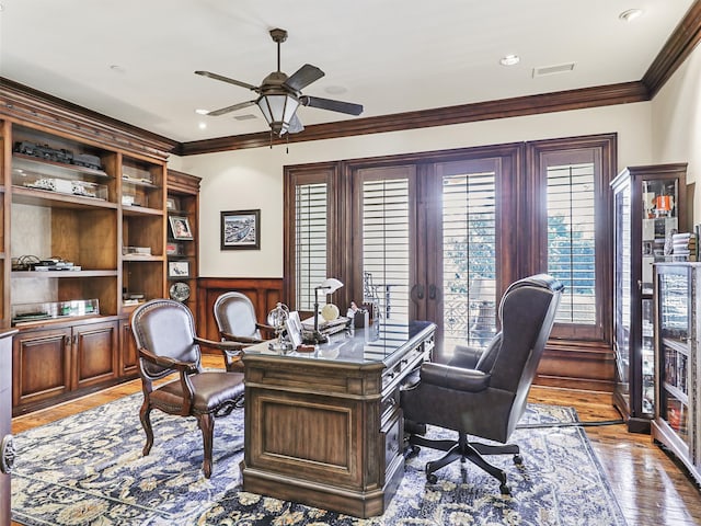 home office with crown molding, light hardwood / wood-style flooring, wooden walls, and ceiling fan