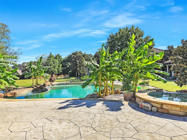 view of pool featuring a patio and an in ground hot tub