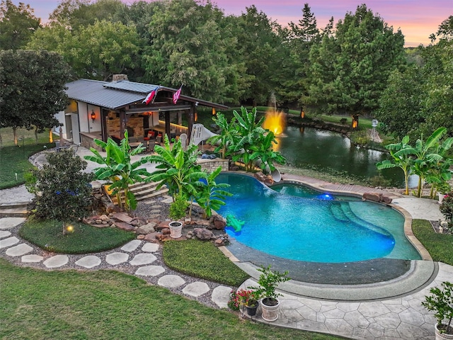 pool at dusk featuring a patio