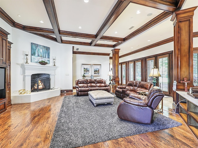 living room featuring coffered ceiling, ornate columns, beam ceiling, ornamental molding, and hardwood / wood-style floors