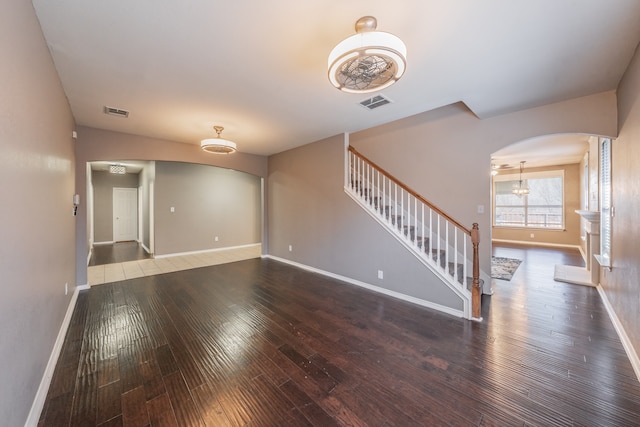 unfurnished room with hardwood / wood-style floors and a chandelier