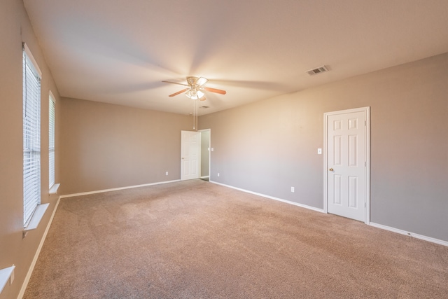 unfurnished room featuring carpet floors, ceiling fan, and a wealth of natural light