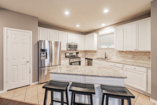 kitchen with white cabinets, stainless steel appliances, and a kitchen island