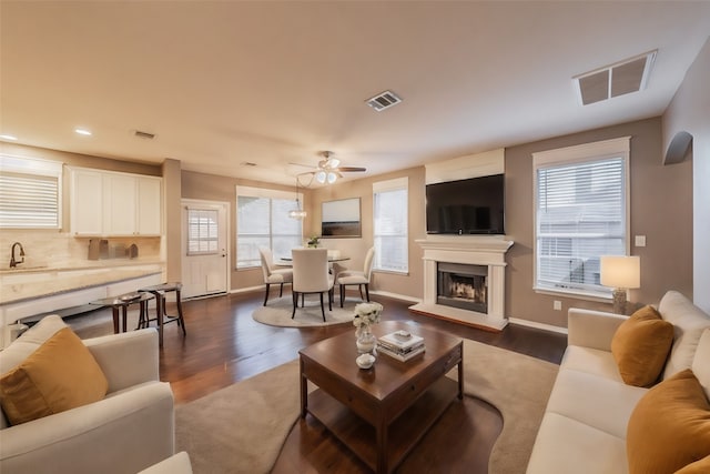 living room featuring sink, ceiling fan, and dark hardwood / wood-style flooring